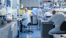 White female lab technician working in the background of a lab setting